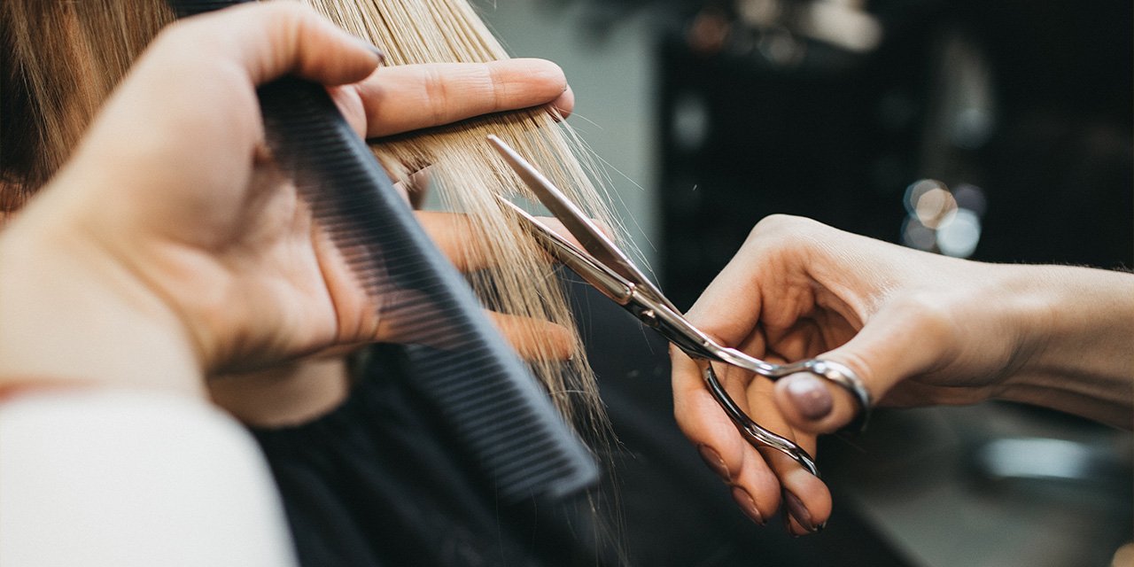 Friseurin beim Haare schneiden